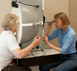 To kvinner på hver sin side av et apparat som måler synsfelt.