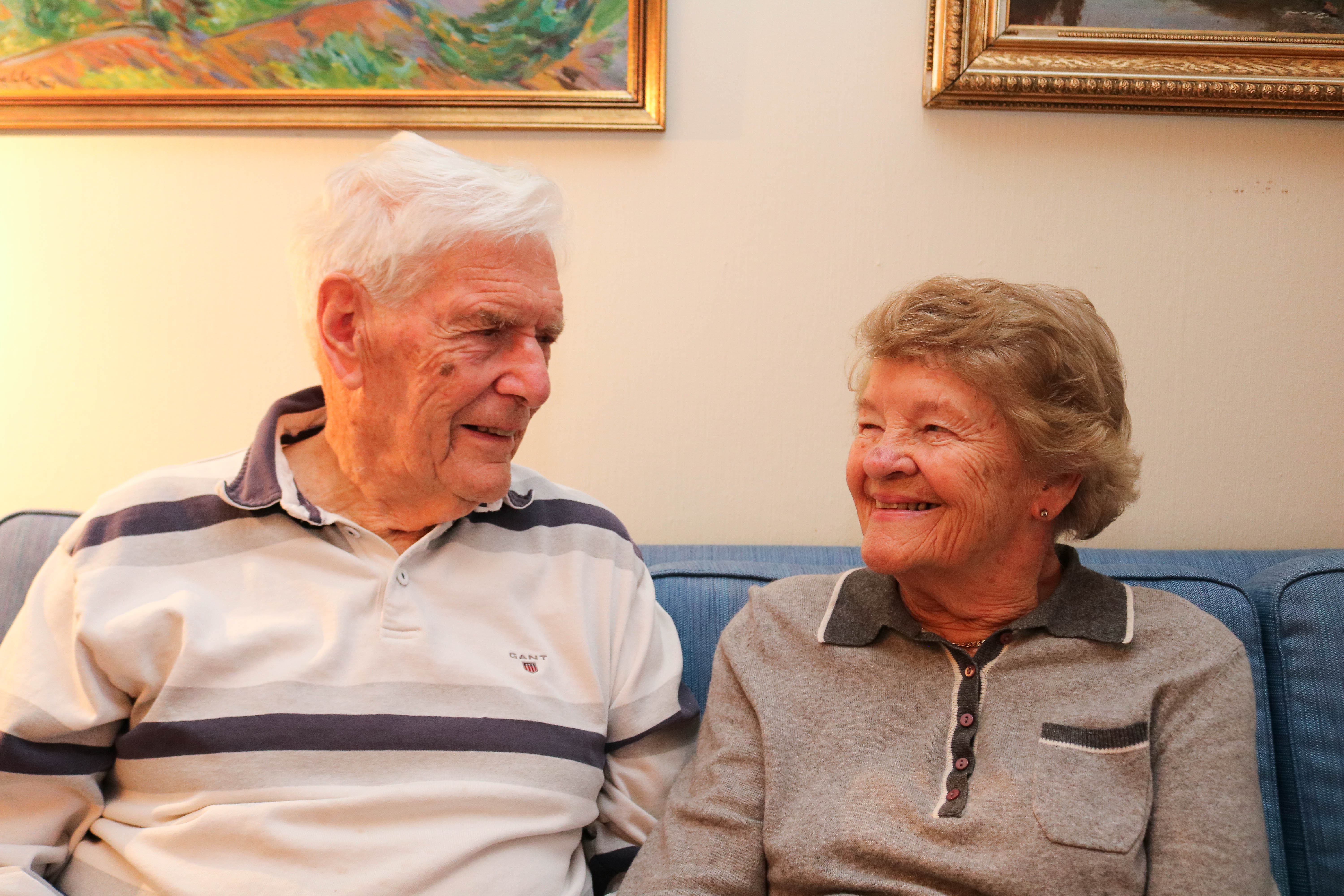 Et eldre par som sitter i en sofa.