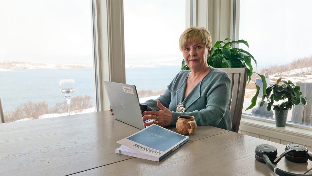 En person som sitter ved et bord med en bærbar datamaskin