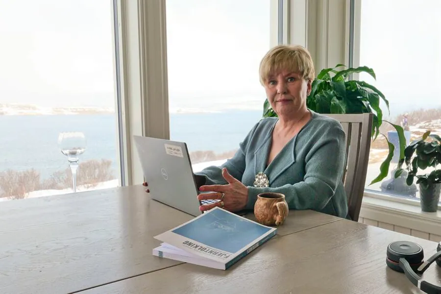 En person som sitter ved et bord med en bærbar datamaskin