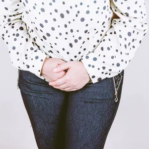 Dame som holder hendene samlet på magen