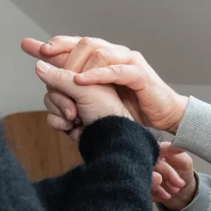 Et nærbilde av hender som holder i hverandre