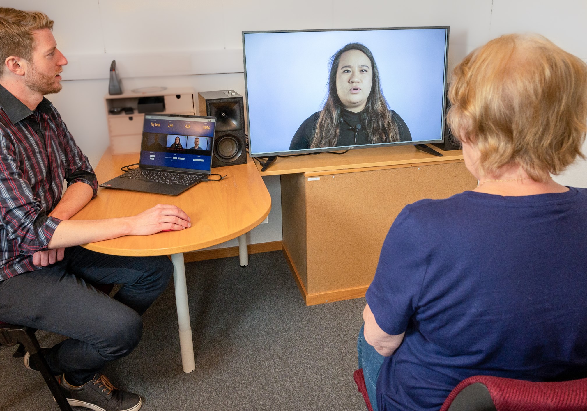 En mann og en kvinne som sitter ved et skrivebord og ser på en datamaskin